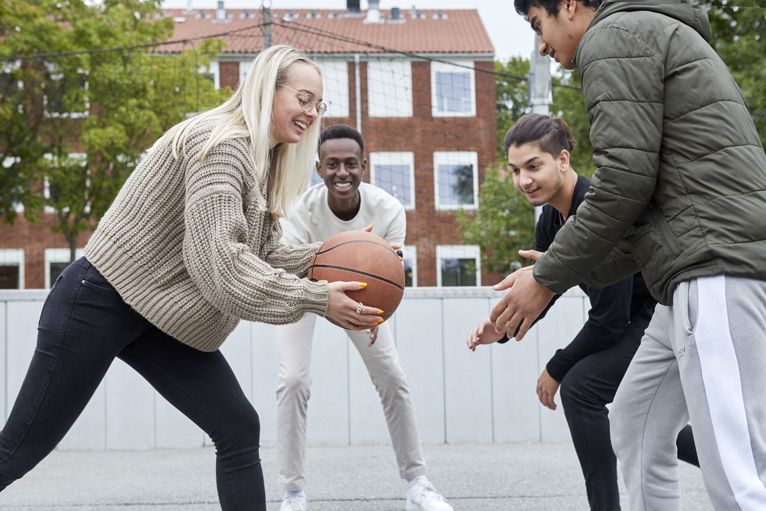 4 unge spiller basketball